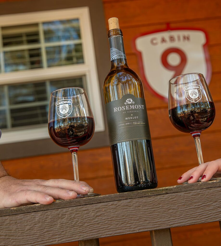 Couple holding wine glasses at a cottage in Camp Cardinal