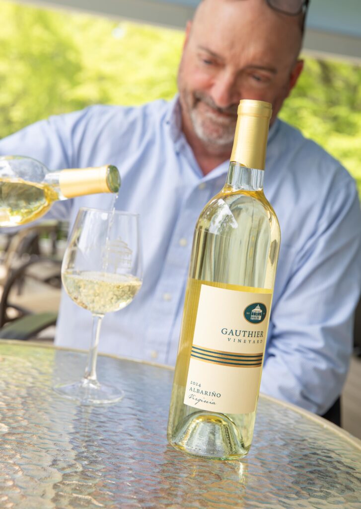 A bottle of Gauthier Vineyard Albariño being poured into a glass by the winemaker.