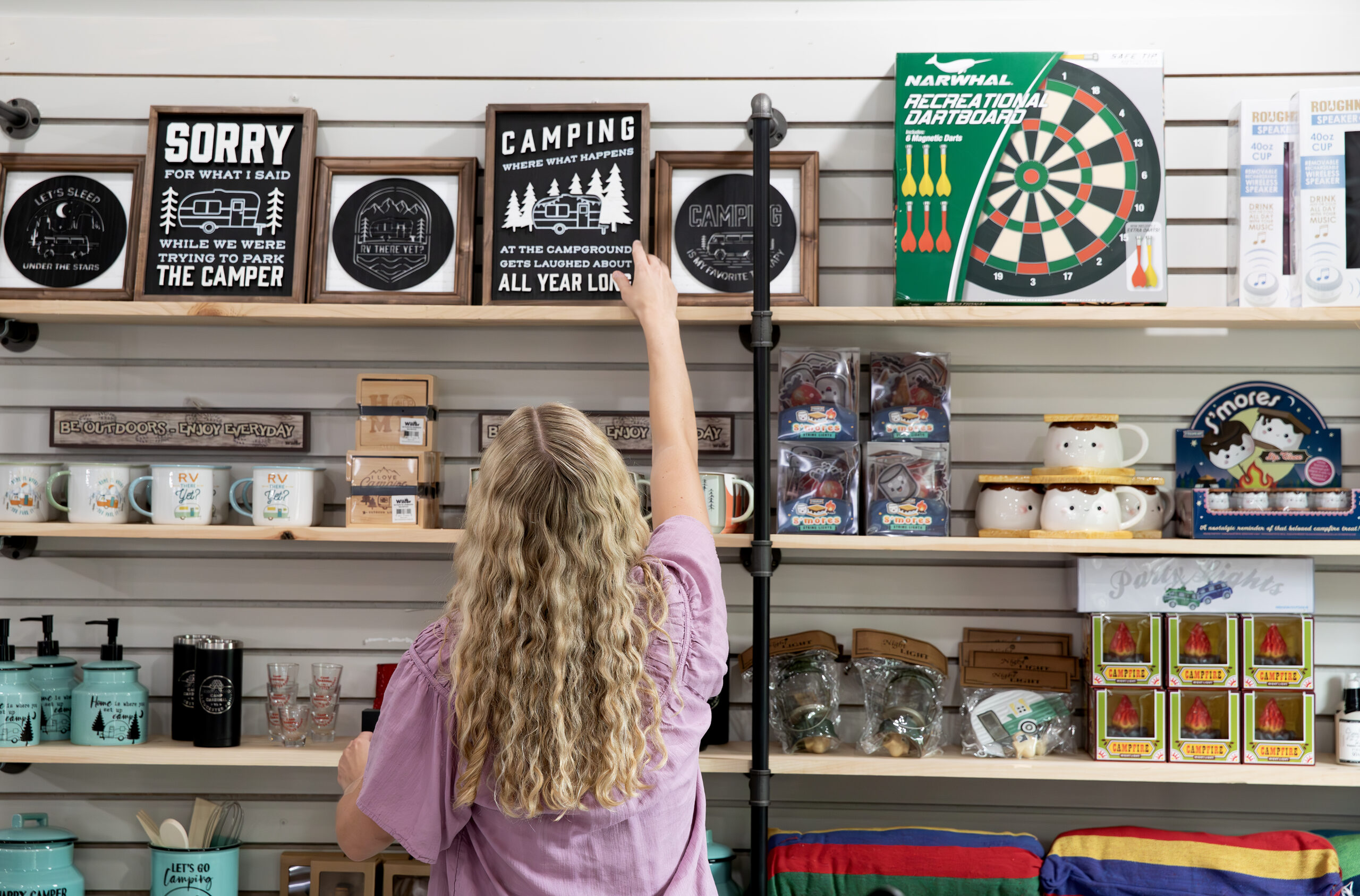 Assortment of funny and cozy camping signs at Camp Cardinal shop