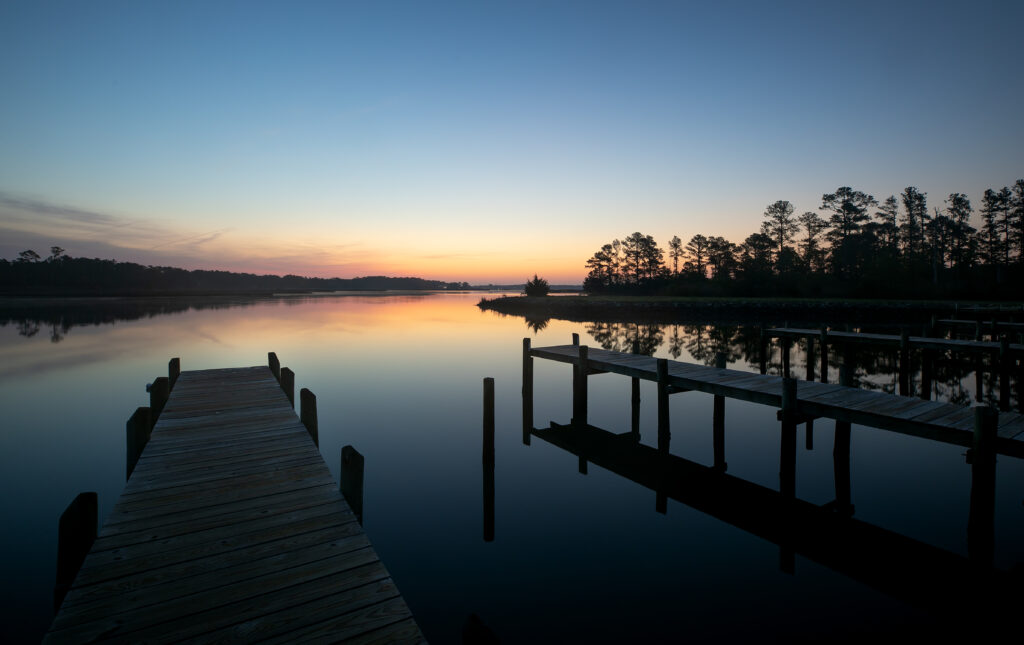 Sunrise reflecting on dockside water near campsite